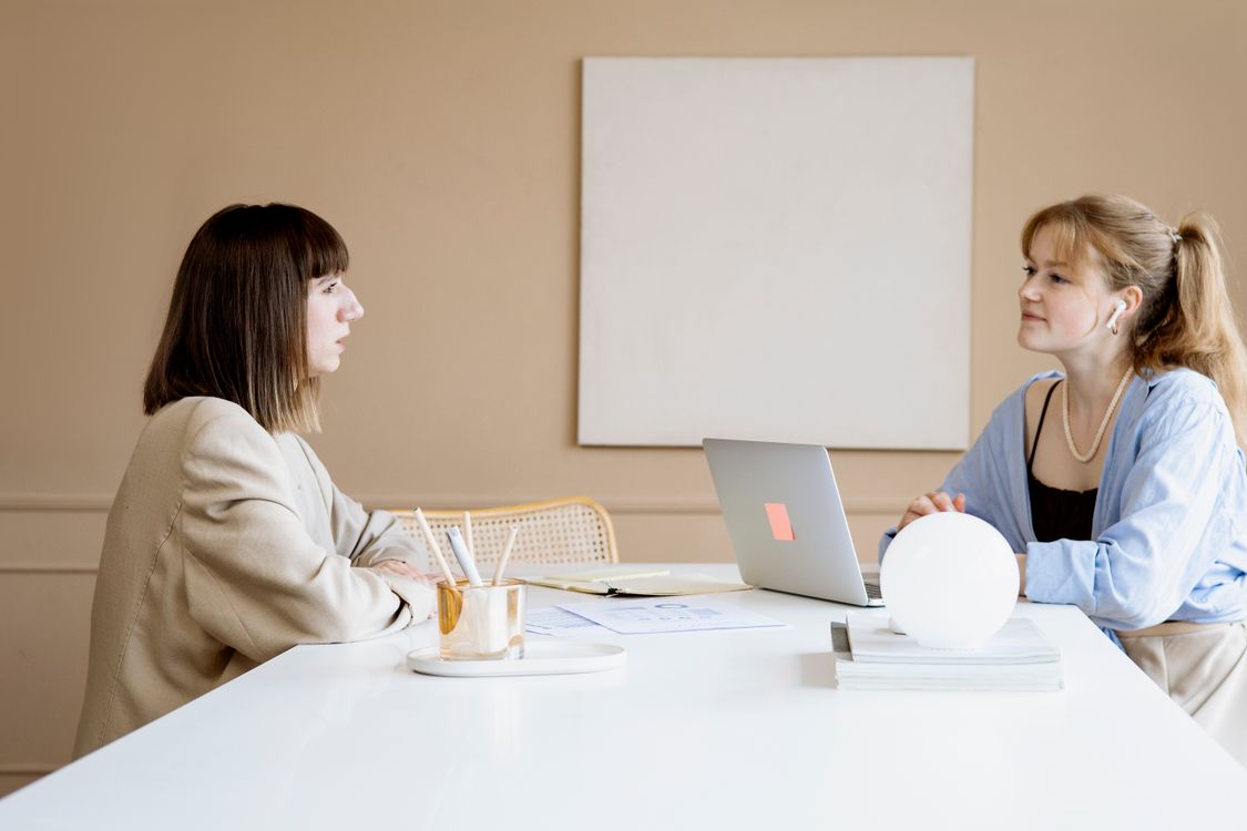 Zwei Frauen tauschen sich am Laptop über nächste Schritte aus